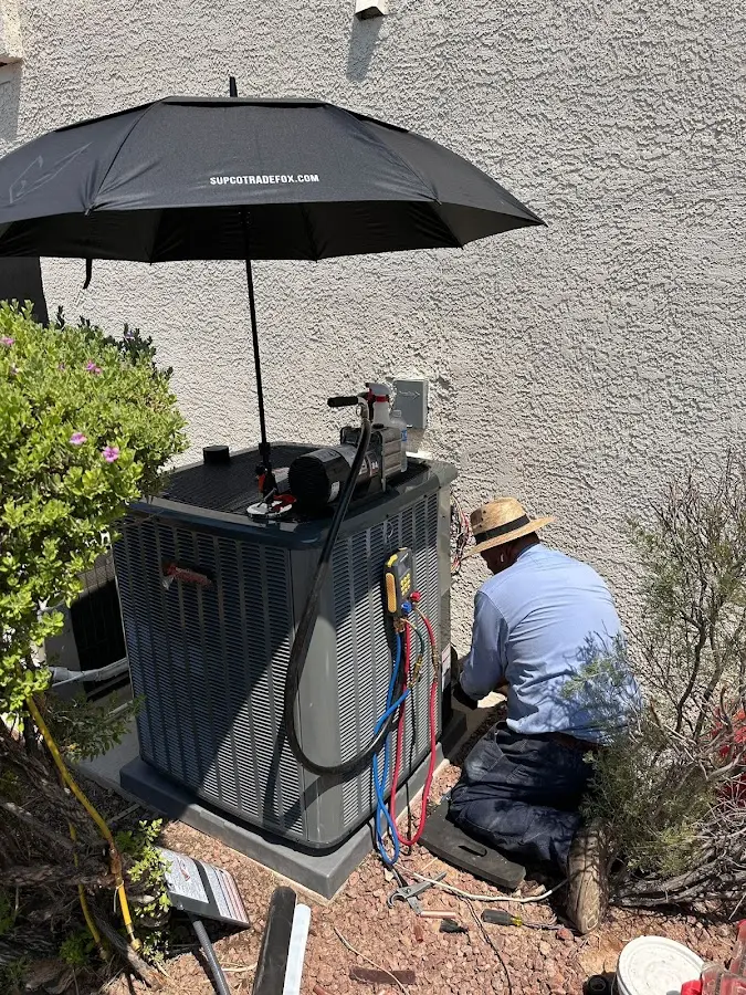 HVAC technician performing outdoor AC maintenance in Sterling
